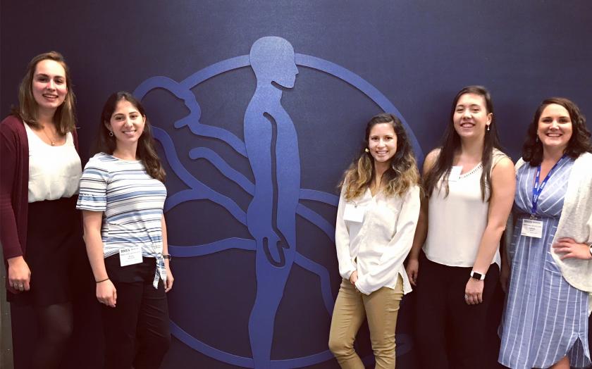 Five Biomedical Engineers stand in front of a medical logo