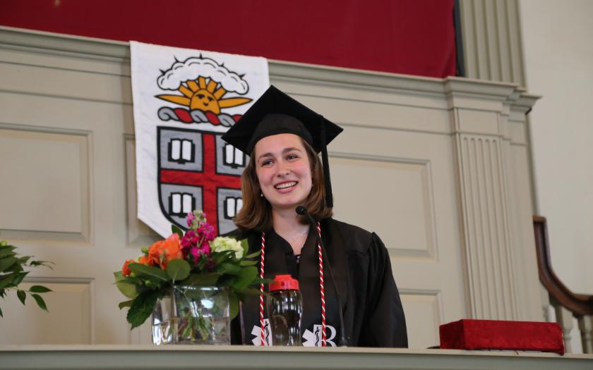 Colette Bare gives the student address in front of the Brown University banner