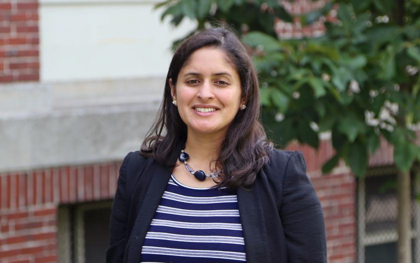 Anita Shukla portrait in front of a brick building and a tree