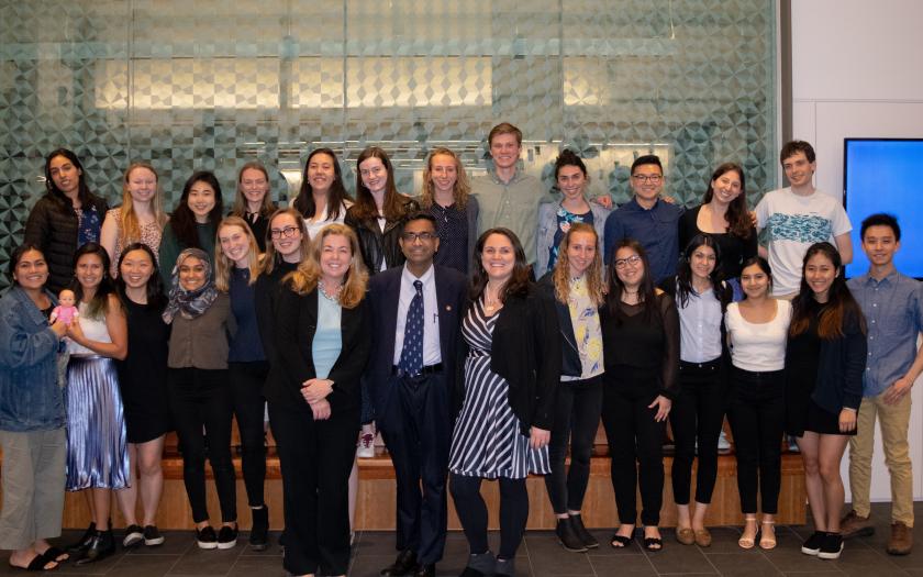 A group of students taking a photo in two rows around three professors
