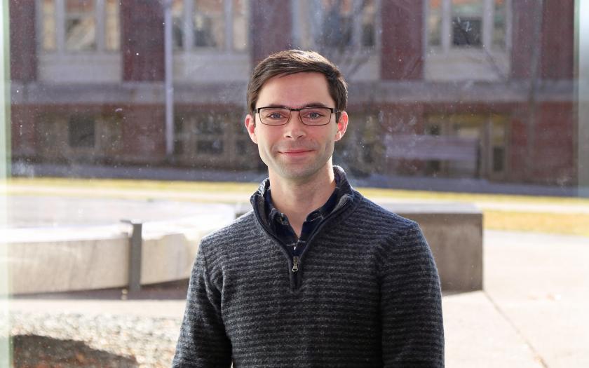 David Borton portrait on campus in front of a brick building