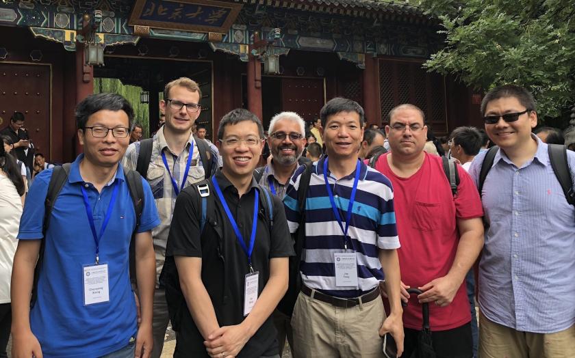 Seven scholars pose in front of Chinese-style gates