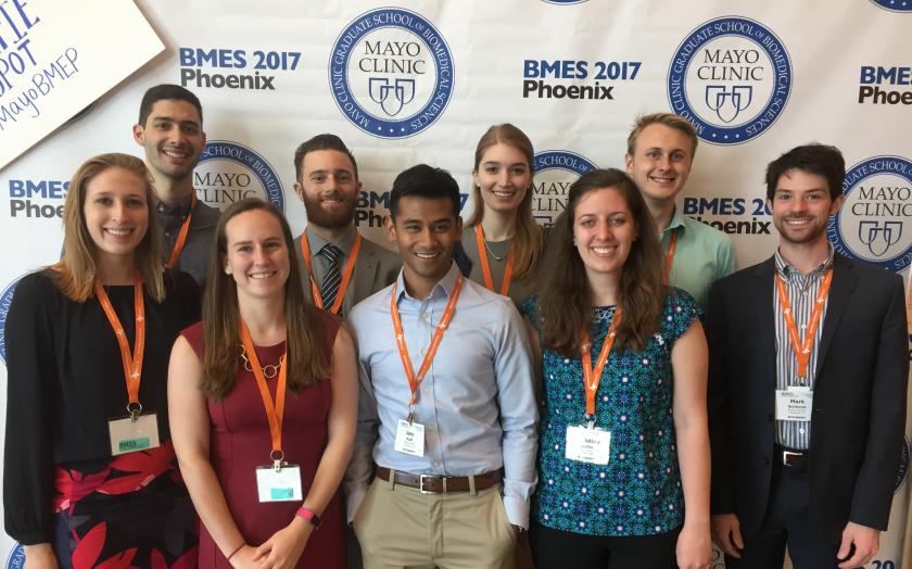 Students wearing lanyards taking a group photo at a conference