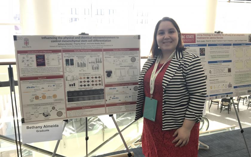 Bethany Almeida next to her research poster