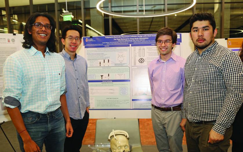 Four students around a poster