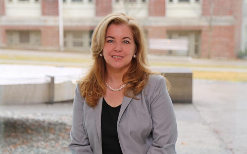Vicki Colvin sits on campus in front of a brick building