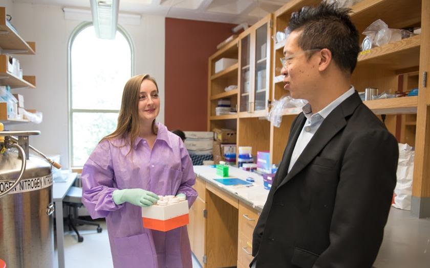 Ian Wong discusses research in a lab