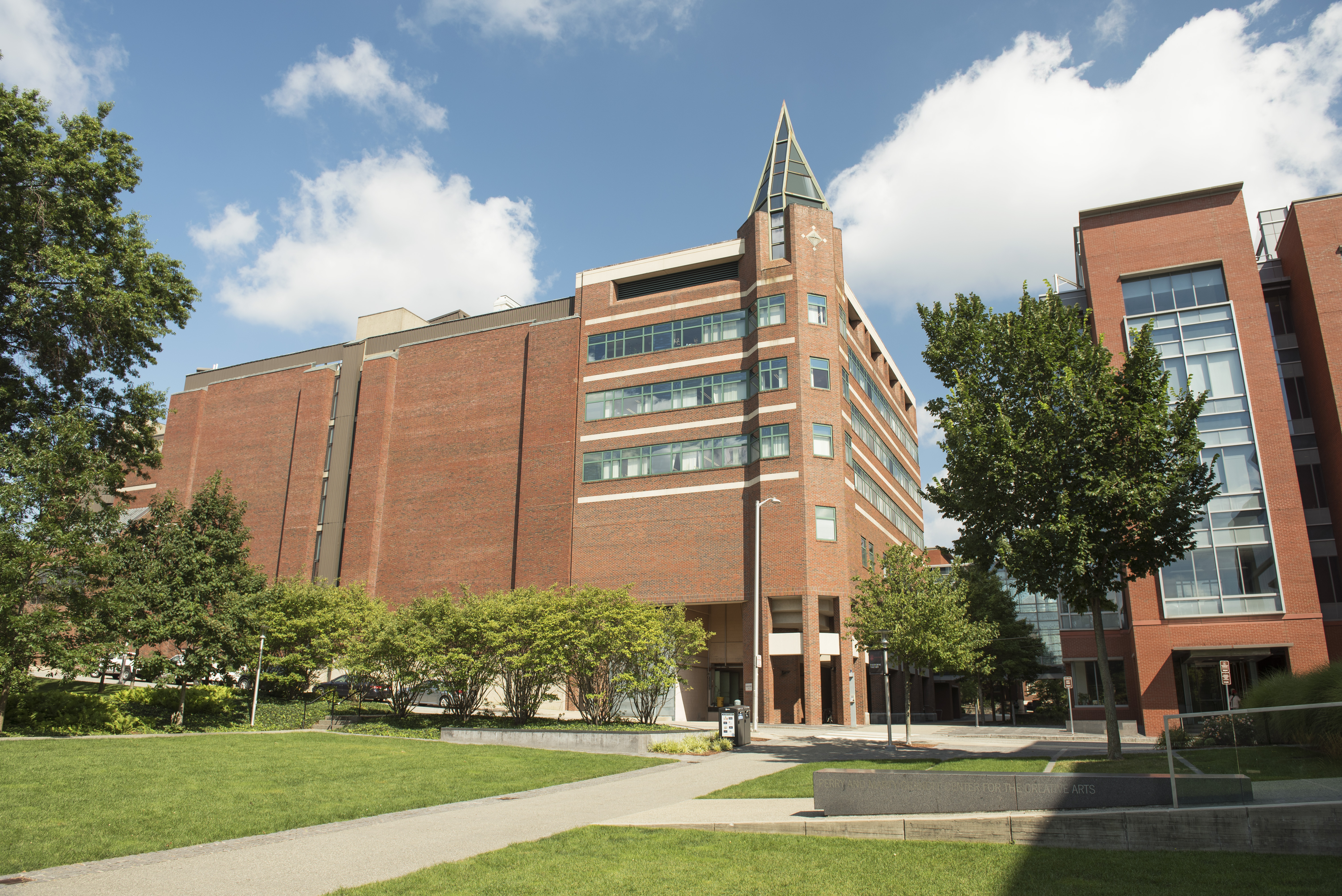 large modern brick building with a green lawn on a sunny day